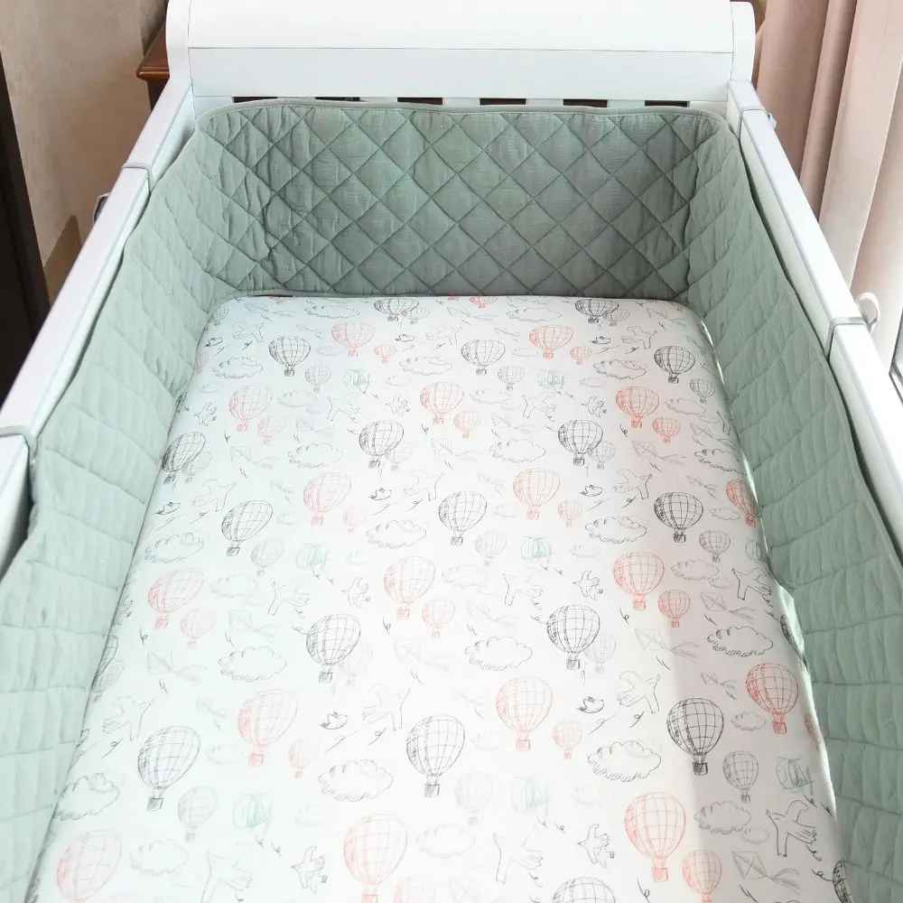 Mint green quilted crib bumper with hot air balloon print sheet for baby's cozy sleep