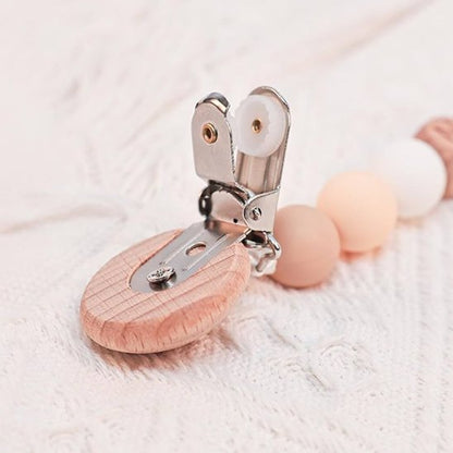 Wooden baby pacifier clip with pastel beads on soft knit fabric
