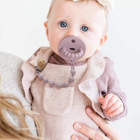 Baby with pacifier and silicone teether necklace for soothing comfort