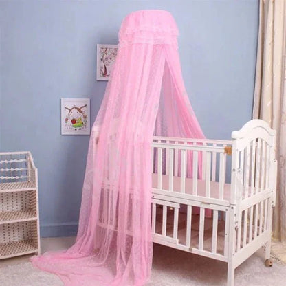 Pink mosquito net canopy over white baby crib in nursery, soft bedding for sweet sleep