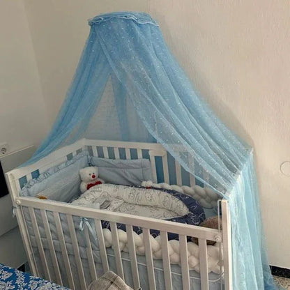Blue canopy over white baby crib with plush toy and soft bedding for cozy infant sleep