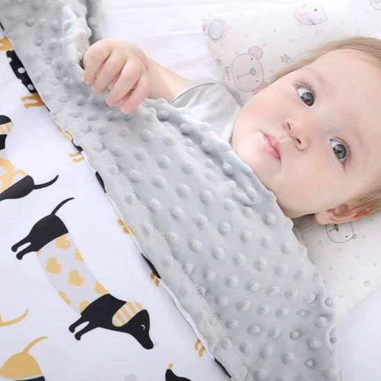 Couverture bébé en tissu moelleux offrant chaleur et douceur pour les siestes quotidiennes
