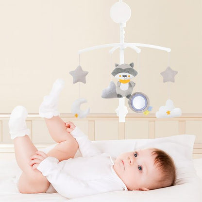 Mobile musical motorisé pour berceau avec une peluche douce de raton laveur gris, un miroir d'éveil et des étoiles suspendus au-dessus d'un bébé couché.