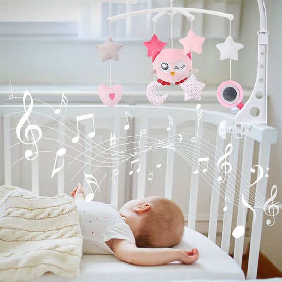 Mobile pour berceau diffusant des mélodies apaisantes avec figurines suspendues de chouette rose, cœur et étoiles, au-dessus d'un bébé couché sur le dos.