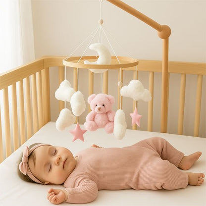 Mobile apaisant pour lit de bébé en bois avec un ourson en peluche rose et des nuages tournant doucement au-dessus d'un nourrisson endormi paisiblement.
