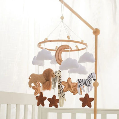 Mobile pour bébé thème savane avec un lion, un zèbre, une lune cuivrée et des nuages sur un support en bois naturel.