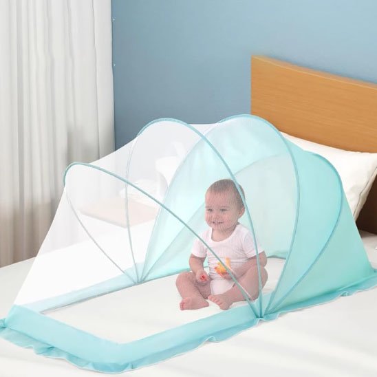 Baby sleeping under light blue mosquito net on bed, safe and cozy sleep environment for infants