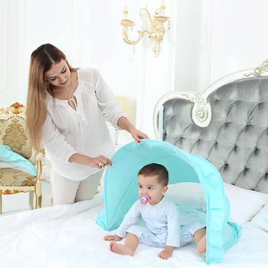 Baby under blue canopy with mom, cozy bedtime setup for sweet sleep