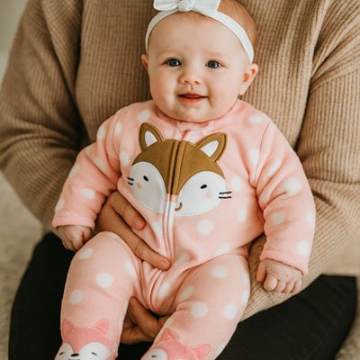 Baby in pink fox-themed sleepwear with polka dots, cozy and adorable for gentle nights