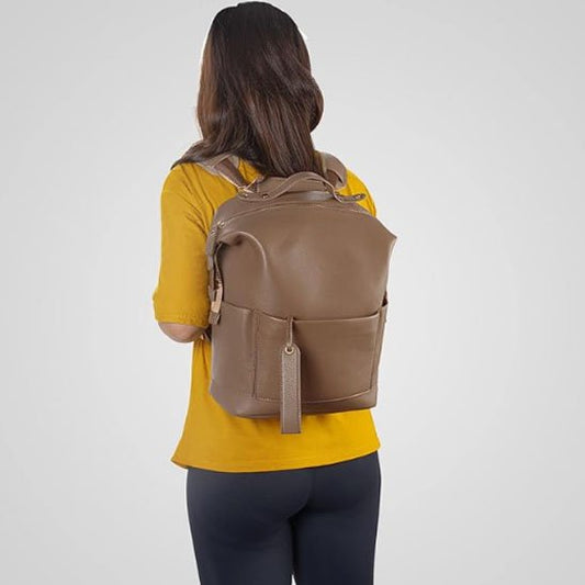 Brown leather diaper bag backpack with front pocket, worn by woman in yellow shirt