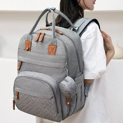 Gray diaper bag backpack with brown accents, perfect for baby essentials and travel comfort.