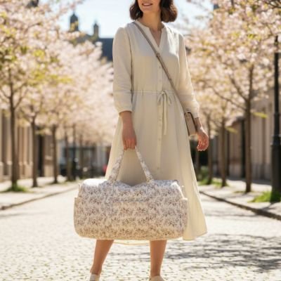 Woman carrying floral baby bag on cherry blossom street for serene parenting moments