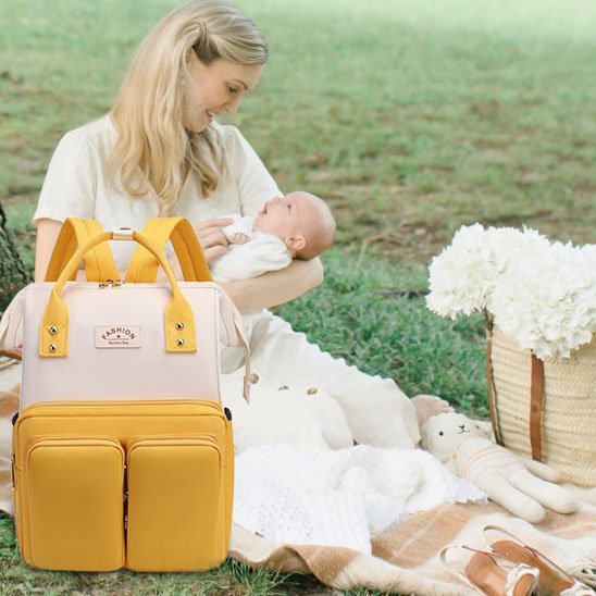 Yellow diaper bag with mom and baby outdoors, perfect for baby essentials and comfort