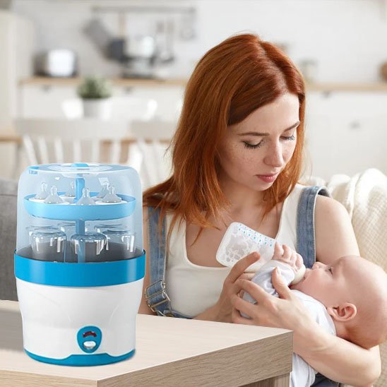 Mother feeding baby with bottle beside blue and white bottle sterilizer for safe baby care