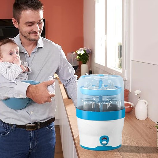 Father holding baby near baby bottle sterilizer for safe, hygienic feeding essentials