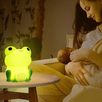 Cute frog night light glowing softly beside mom holding baby, perfect for soothing bedtime routines.